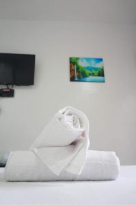 ein weißes Handtuch auf dem Bett in der Unterkunft Sheryl May Inn in El Nido