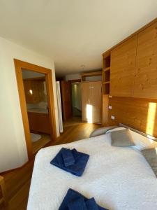 Monolocale Stelvio- Residenza Vallecetta 2 في بورميو: غرفة نوم بسرير كبير عليها وسائد زرقاء