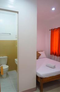 ein Schlafzimmer mit einem Bett, einem WC und einer Dusche in der Unterkunft Sheryl May Inn in El Nido