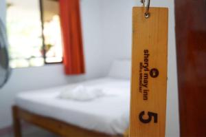 eine hölzerne Fledermaus hängt in einem Zimmer mit einem Bett in der Unterkunft Sheryl May Inn in El Nido
