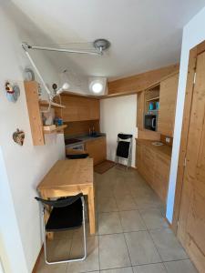 a small kitchen with a wooden table and chairs at Monolocale Stelvio- Residenza Vallecetta 2 in Bormio
