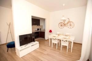 a living room with a dining table and a television at Portico ventizerodue in Merano