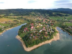 an island in the middle of a river with houses at Domki w Zawozie nad Soliną in Zawóz