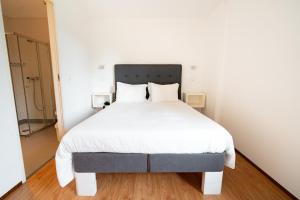 a bedroom with a large bed with white sheets at Hotel A Ponte in Viana do Castelo