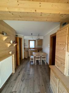 a kitchen and dining room with wooden floors and wooden walls at Trilocale Ortles - Residenza Vallecetta 2 in Piatta