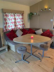 sala de estar con mesa y sofá en DaisyChain 2 Getaways - The perfect place to Stay - Play - Getaway en East Mersea
