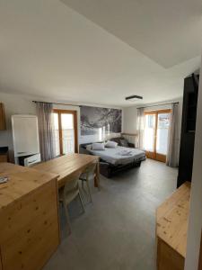 a living room with a bed and a table and a room at Mansarda Tresero- Residenza Vallecetta 2 in Piatta