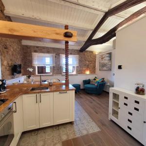 a kitchen with white cabinets and a living room at Casa de Casal in Lestedo