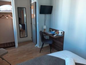 a bedroom with a desk with a chair and a mirror at Hotel Le Rochegude in Albi