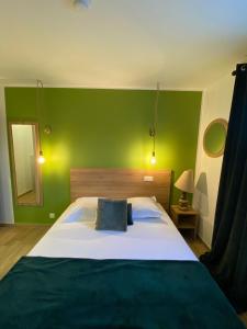 1 dormitorio con 1 cama grande y pared verde en Hotel U Catagnu, en San-Nicolao