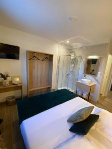 1 dormitorio con 1 cama blanca grande y lavamanos en Hotel U Catagnu, en San-Nicolao