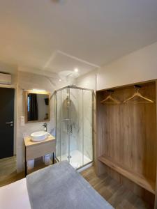 a bathroom with a shower and a sink and a bed at Hotel U Catagnu in San-Nicolao