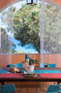 una mesa con dos copas de vino y un árbol en Le Sunrise - Appartamenti a 350 mt dal mare e con giardino privato, en Cala Liberotto 54 fotos más