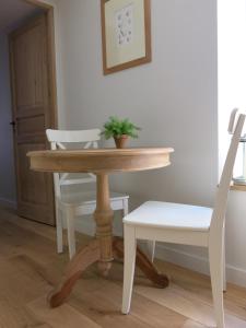 a table and a chair with a potted plant on it at Les Petits Volets 3 appartements au choix in Antibes