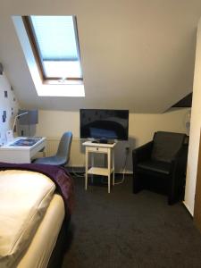 a bedroom with a bed and a tv and a chair at Landhaus Streeck in Rüggow