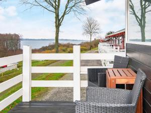 un porche con una valla blanca, una mesa y sillas en Holiday home Aabenraa LV en Aabenraa