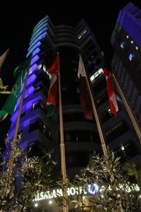 Al Salam Hotel في الكويت: مبنى طويل مع أعلام أمامه
