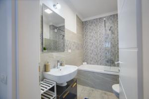Un baño con lavabo, inodoro y bañera. en Retreat to a Stylish Home at West Residence, en Oradea