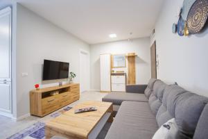 Una sala de estar con un sofá y un televisor. en Retreat to a Stylish Home at West Residence, en Oradea 29 fotos más