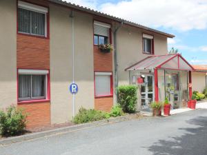 a building with a parking sign in front of it at Hôtel Restaurant du Lac in Graulhet