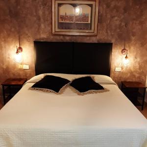 una camera da letto con un letto bianco con due cuscini sopra di Hotel Victoria a Firenze