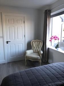 1 dormitorio con silla y ventana en Oak Tree Lodge en Westport