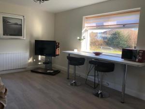 a room with a desk with two stools and a window at Oak Tree Lodge in Westport