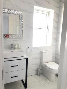 a white bathroom with a sink and a toilet at Oak Tree Lodge in Westport