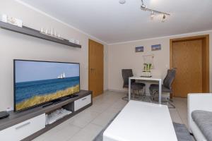 a living room with a flat screen tv and a table at Ostseetraum in Kühlungsborn