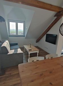 uma sala de estar com um sofá e uma mesa em Landapartments Smitmans em Kerken