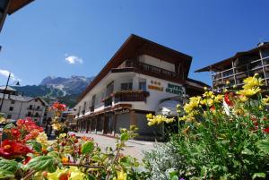 a building with a bunch of flowers in front of it at Hotel Olimpia in Cortina dʼAmpezzo