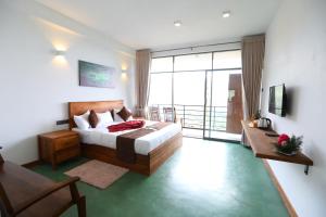 a bedroom with a bed and a balcony at Icy Falls - Ohiya in Ohiya