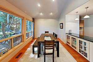a dining room with a table and some windows at Tree Branch Cabin in Sunriver