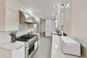 a kitchen with white cabinets and a stove top oven at Krikwood Place in Seattle
