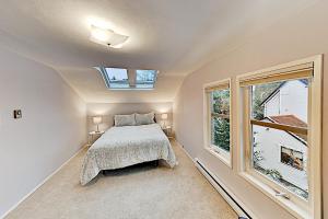 西雅圖的住宿－Krikwood Place，一间卧室设有一张床和两个窗户。