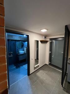 Habitación con puerta de cristal y baño. en Retro Retreat Unique Industrial Design apartment en Cluj-Napoca