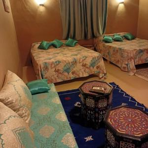 Zimmer mit 2 Betten und grünen Kissen in der Unterkunft LESCALE DE OUARZAZATE in Ouarzazate