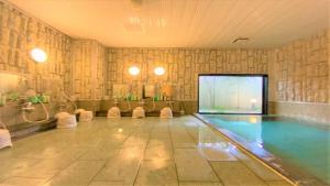 een binnenzwembad met een zonneklep voor baantjes bij Hotel Route-Inn Tsuruoka Inter in Tsuruoka