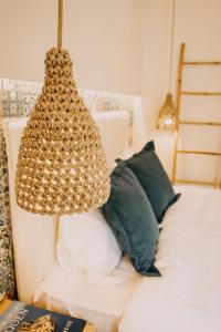 a chandelier hanging over a bed with green pillows at Loutraki Hidden Gem Ι in Loutraki
