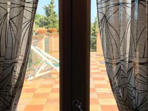 a view of a patio from a window with curtains at Altopiano in Finale Ligure