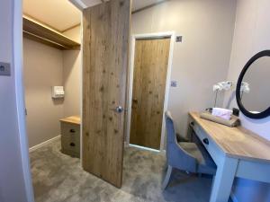 a bathroom with a blue desk and a mirror at Daphne's Lodge in Mawgan Porth