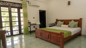 a bedroom with a bed and a desk in it at Iwamisou in Sigiriya