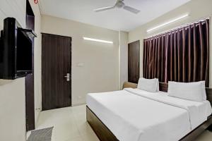 a bedroom with a white bed and a window at Hotel Nova Vatika in Surat