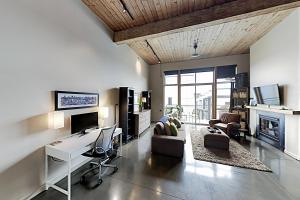 sala de estar con escritorio y sofá en 19th Avenue Lofts Unit 213 en Seattle