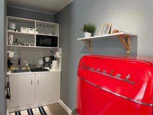 a kitchen with a red refrigerator in a room at Квартира-студия с отдельным входом с гостиничным сервисом, с белым постельным in Petropavlovsk