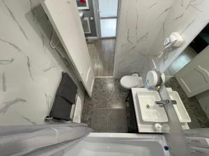 a white bathroom with a sink and a toilet at Квартира-студия с отдельным входом с гостиничным сервисом, с белым постельным in Petropavlovsk
