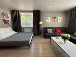 ein Wohnzimmer mit einem Bett und einer Couch in der Unterkunft Квартира-студия с отдельным входом с гостиничным сервисом, с белым постельным in Petropawlowsk
