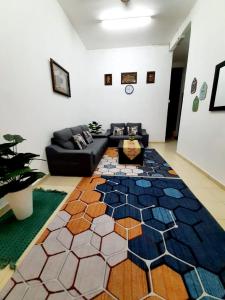 AMZ HOMESTAY في مسجد طنة: غرفة معيشة مع أريكة وسجادة ملونة