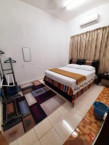 a bedroom with a bed and a cross on the floor at AMZ HOMESTAY in Masjid Tanah