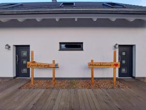 two wooden benches sitting in front of a building at Ferienhaus Britta Kietzmann in Feldberg